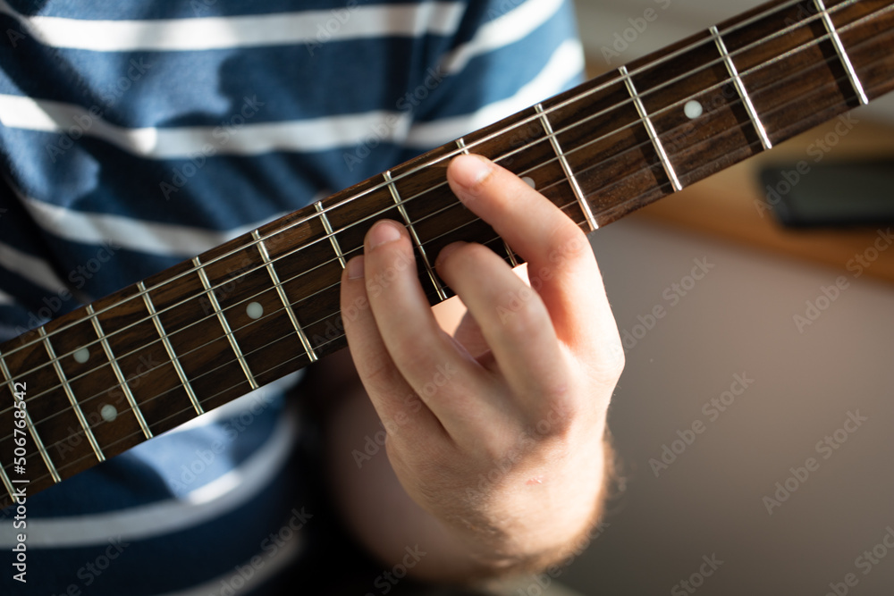 Fototapeta premium A man plays electric guitar. Macro photo. Front view.