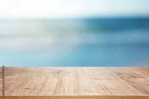 Sticker Wooden table and blurred sea background. Summertime and vacation