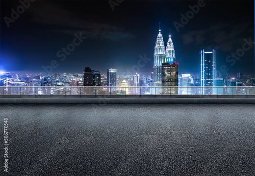 Kuala lumpur urban cityscape skyline night scene with empty asphalt floor on front.