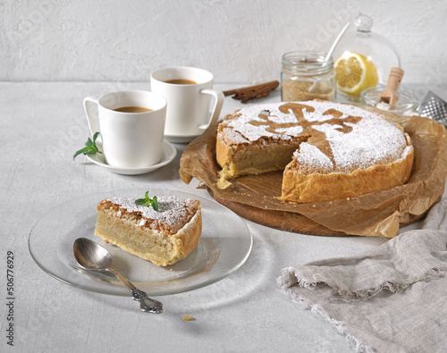 Fotografie tarta de santiago and a peace and coffee cups, spanish almond cake, morning conc