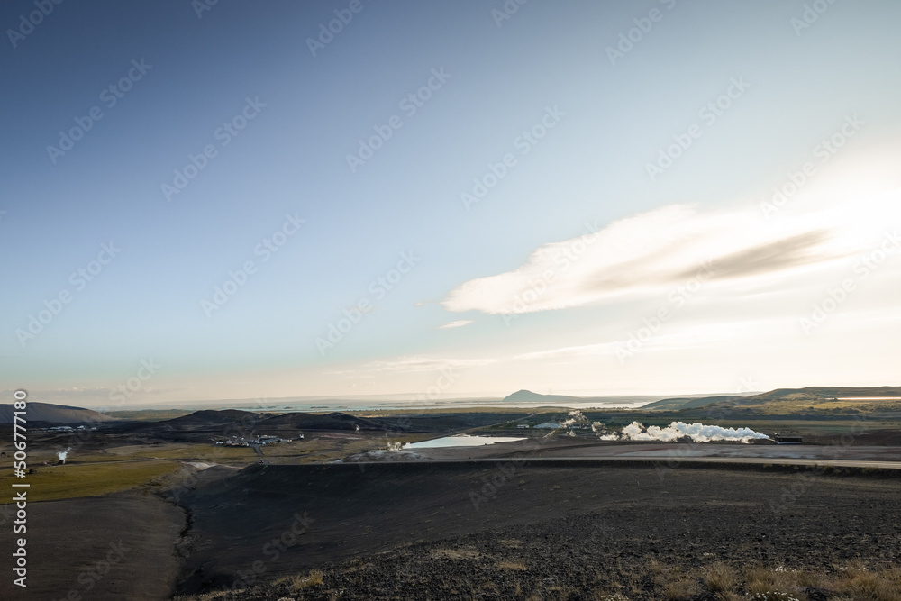 View of thermoelectric geothermal power and heating plant close to Krafla, Iceland with visible pipes, scenery, lake, tower, cooling tower and other stuff.