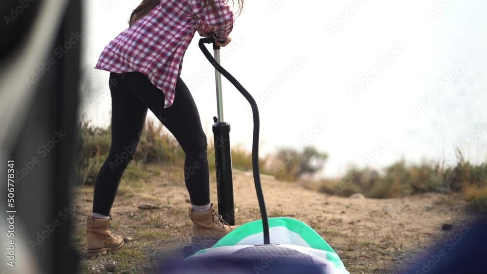 Female Inflating Air in Rubber Paddle With Manual Pump, Slow Motion