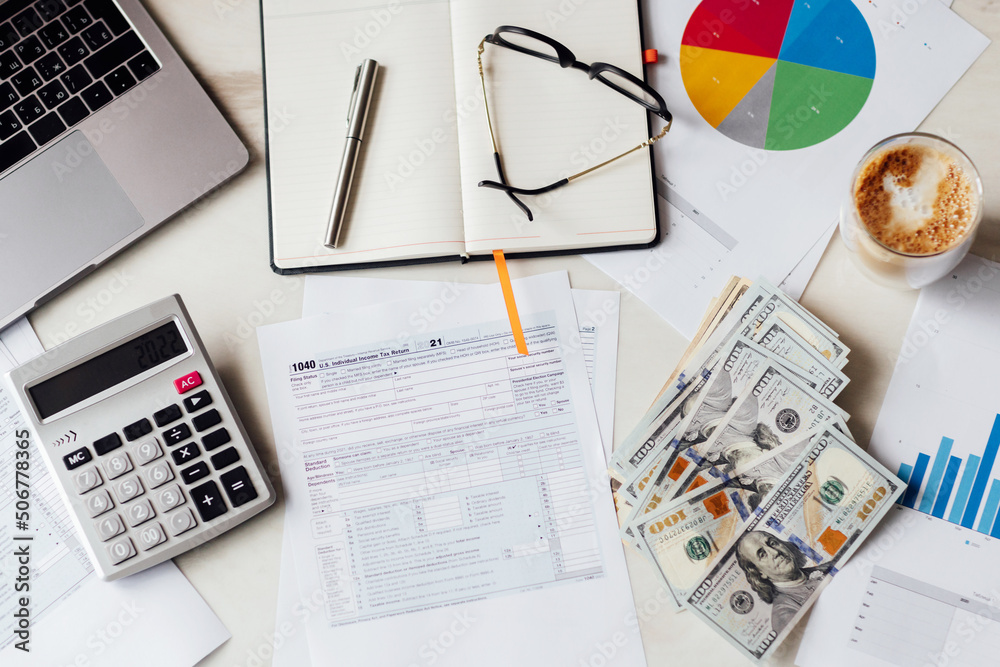 Fototapeta premium Working desk with tax form, laptop, coffee glass and calculator. Business financial and accounting concept.