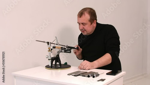 blogger conducts an online master class on sharpening knives on a hand machine.