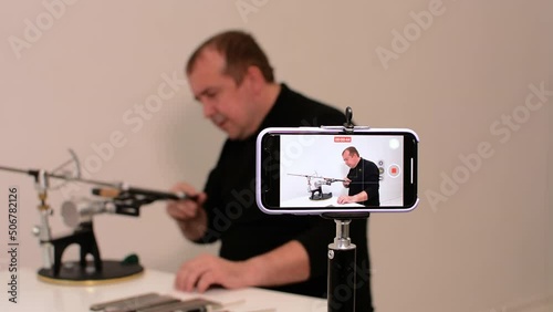 blogger conducts an online master class on sharpening knives on a hand machine.