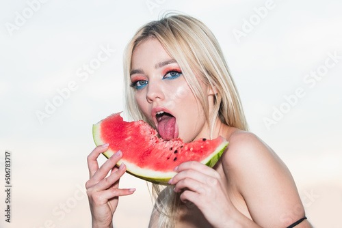 Sexy summer tropical fruit. Sensual young woman lick watermelon with sexy tongue. Sexy summer. photo