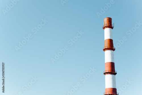 Foto Tall factory chimney without smoke against clear blue sky on sunny day outdoors,