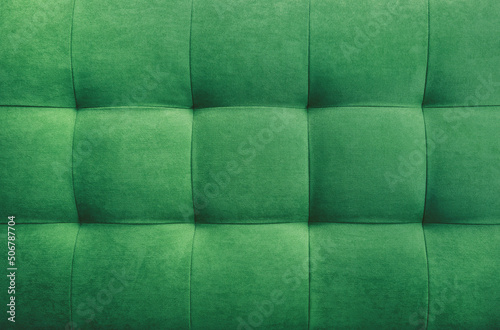 Green suede leather background for the wall in the room. Interior design, headboards made of furniture fabric, furniture upholstery. Classic checkered pattern for furniture, wall, headboard photo