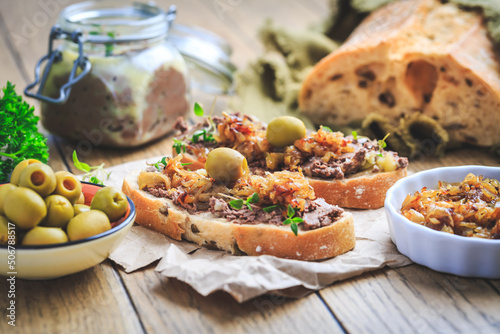 Fresh homemade chicken liver pate on ciabatta bread with roasted onions and olives