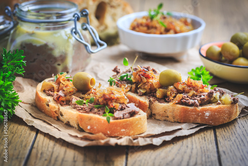Fresh homemade chicken liver pate on ciabatta bread with roasted onions and olives