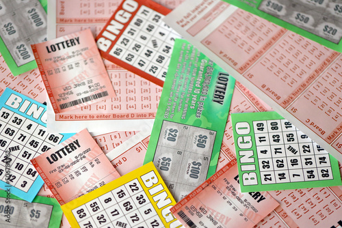 Many used lottery tickets, bills with numbers and bingo playing boards in big pile. Gambling and lottery paper stuff photo