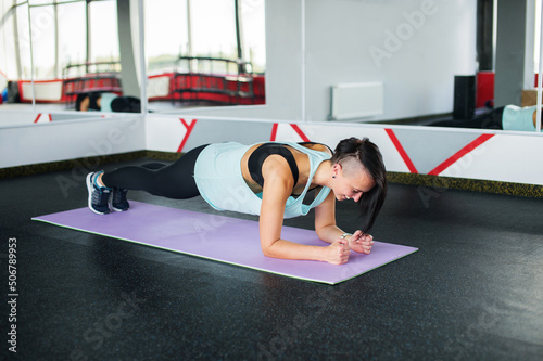The girl coach does stretching in the gym. © Julia Jones