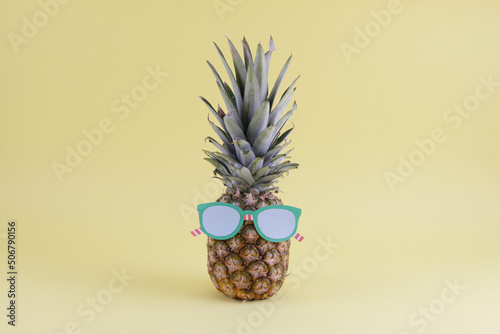 pineapple wearing glasses on yellow background
