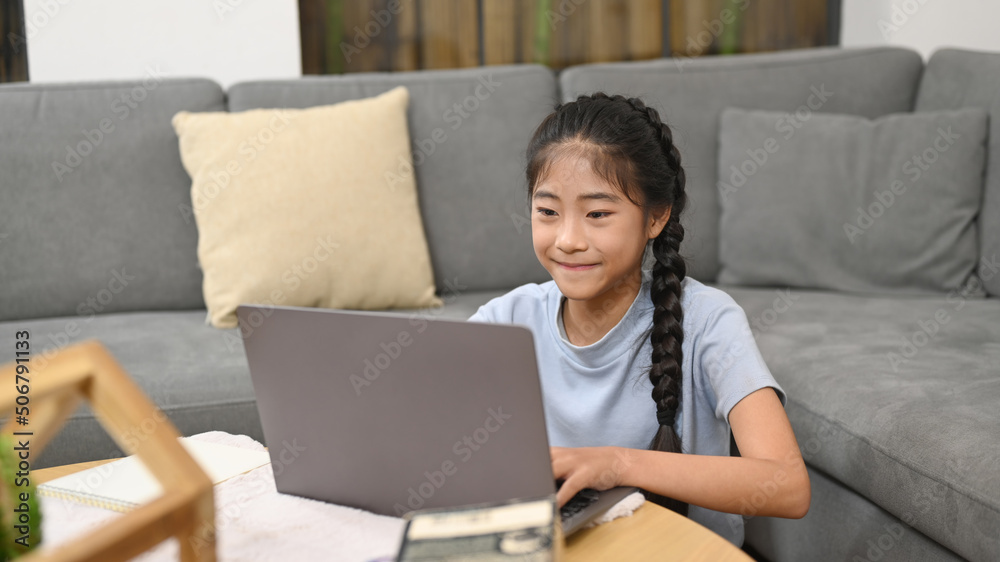 Happy asian girl sitting on floor in living room and using laptop computer. Education and school concept Happy asian girl sitting on floor in living room and using laptop computer. Education and school concept