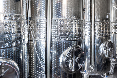 Close up of a wine factory with small steel tanks for storage and fermentation of arrenge of a wine, alcohol drink concept