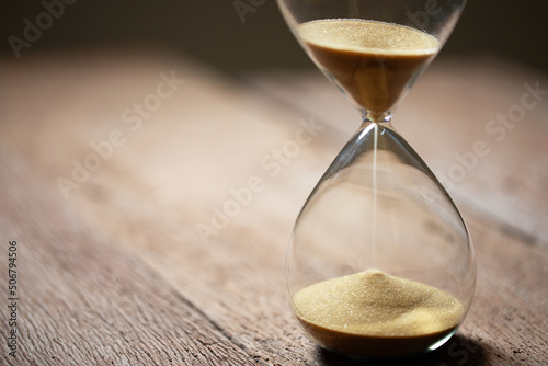 hourglass (sand clock) on an old wooden table, Hourglass as time passing concept for business deadline, Life-time passing concept, elapsed time concept, copy space