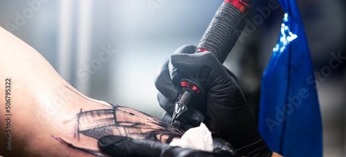 Close up of a tattoo artist tattoos a black tattoo with paint, tattoo fill out a tattoo circuit, tattoo process