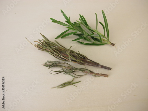 Fresh and dried rosemary on a wooden board
