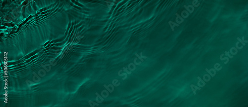 Transparent dark green clear water surface texture with ripples and splashes. Abstract summer banner background Water waves with copy space, top view. Cosmetic moisturizer micellar toner emulsion