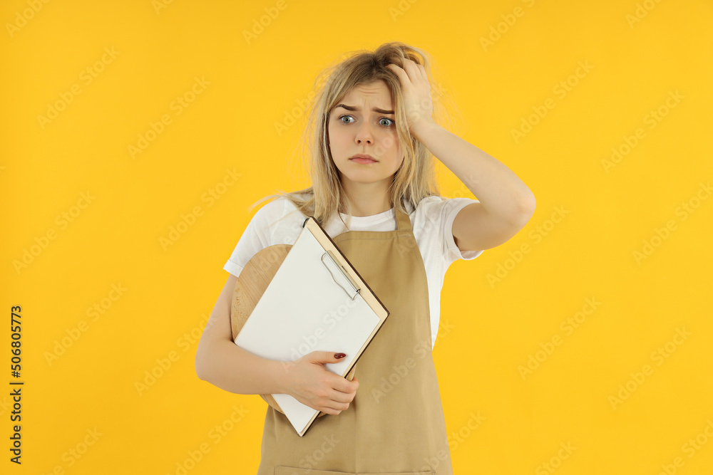Concept of occupation, young female waiter on yellow background Concept of occupation, young female waiter on yellow background
