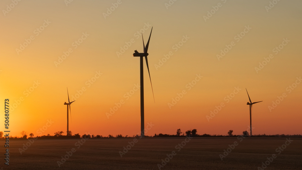 Wind turbine farm over sunset. Green Energy. Wind generators turbines at sunrise.