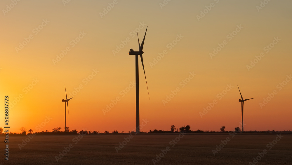 Obraz premium Wind turbine farm over sunset. Green Energy. Wind generators turbines at sunrise.