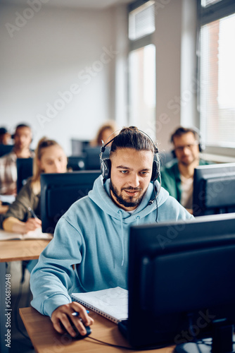 Young student e-leaning during computer class in classroom.