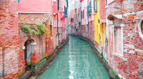 Narrow canal with red brick houses -  Venice, Italy © muratart