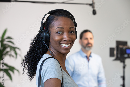 Fotobehang African American Woman Smiling Wearing Headphones Working as an Audio Person on a Video Production Set