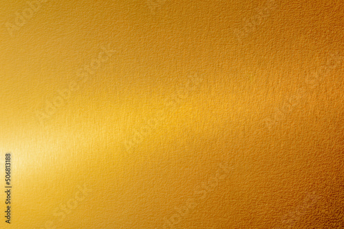 Gold wall texture background. Yellow shiny gold metal sheet surface with light reflection, vibrant metallic golden luxury wallpaper