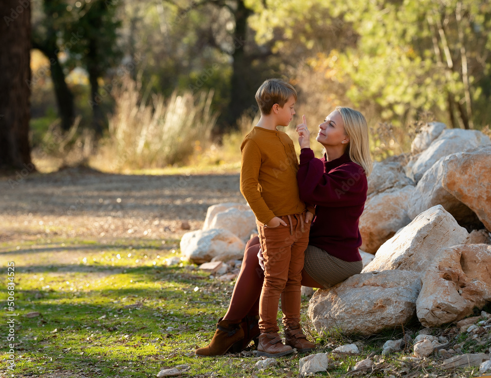 Fototapeta premium Mom and son have a nice chat in the autumn season.