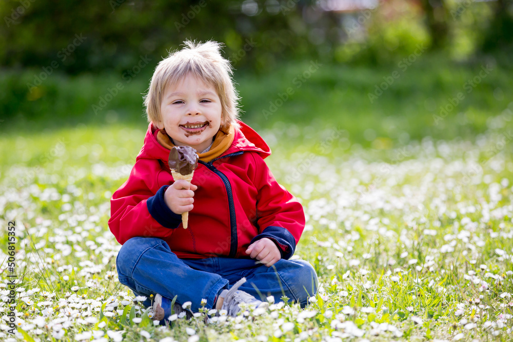 Cute blond child, boy, eating ice cream in the park Cute blond child, boy, eating ice cream in the park