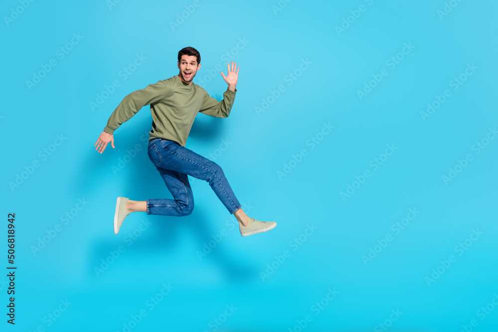 Full body photo of satisfied glad young person enjoy running jump isolated on blue color background Full body photo of satisfied glad young person enjoy running jump isolated on blue color background