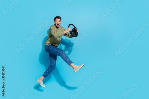Full length photo of funky millnnial brunet guy run drive wear shirt jeans footwear isolated on blue background