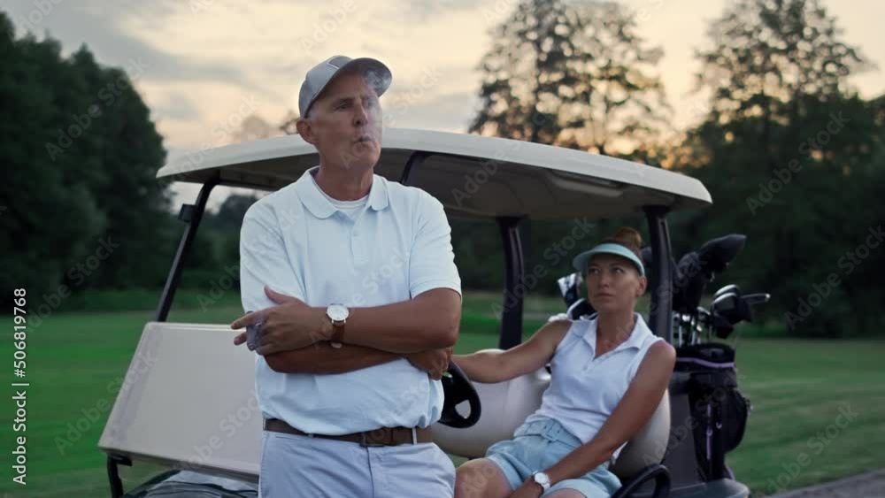 Rich couple enjoy golf evening on fairway. Family golfers relax summer holiday. Rich couple enjoy golf evening on fairway. Family golfers relax summer holiday.