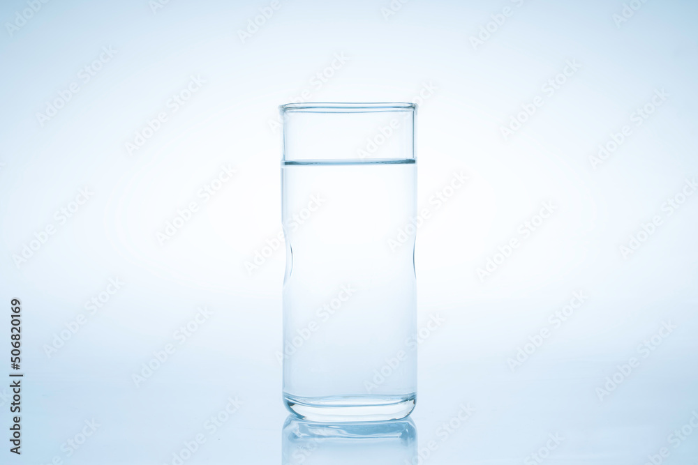 Ice cube fell into the glass of water.Water splashed from the clear glass.Fresh concept Ice cube fell into the glass of water.Water splashed from the clear glass.Fresh concept