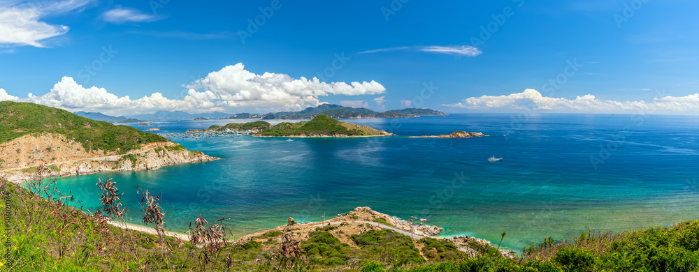 Fototapeta premium Nha Trang Bay summer days with sea light blue, cool, temperate climate, recognized most beautiful bays national scenic Vietnam, boats avoid storm far when rainy season comes.