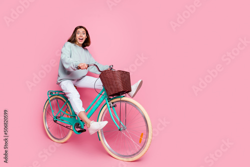 Fototapeta Naklejka Na Ścianę i Meble -  Full size profile side photo of young girl adventure fooling speed ride bicycle isolated over pink color background