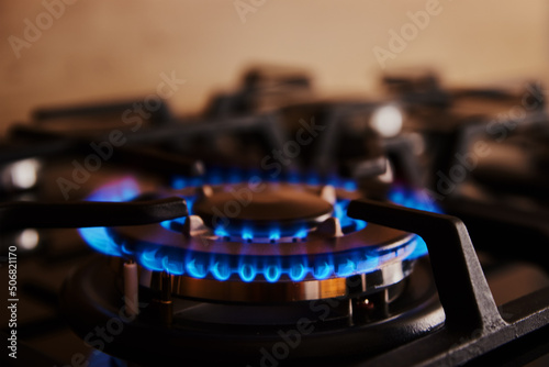 Close up of blue flame on gas stove burner