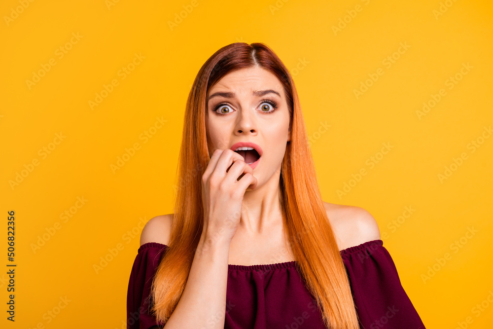 Portrait of scared unsatisfied negative girl hand near mouth stare isolated on yellow color background Portrait of scared unsatisfied negative girl hand near mouth stare isolated on yellow color background