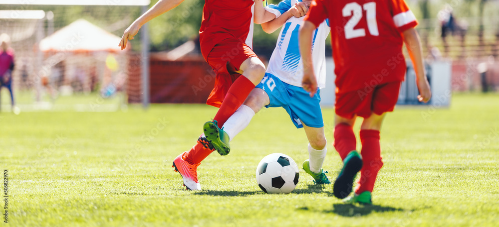Young Boys Compete in Tournament Match in a Duel. Football Game on Summer Sunny Day. School Kids in Red and Blue Jersey Uniforms Running Classic Soccer Ball on Grass Pitch Young Boys Compete in Tournament Match in a Duel. Football Game on Summer Sunny Day. School Kids in Red and Blue Jersey Uniforms Running Classic Soccer Ball on Grass Pitch