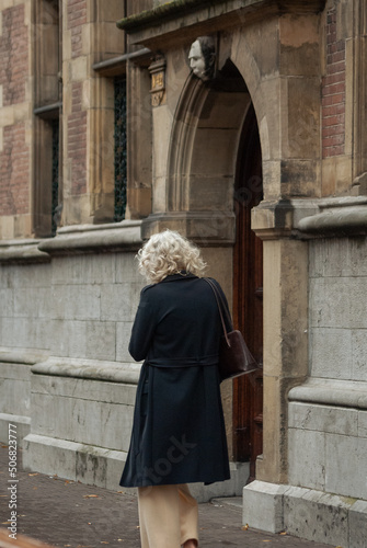 Old lady walking by a historic cathedral church in the center of the Hague in the Netherlands