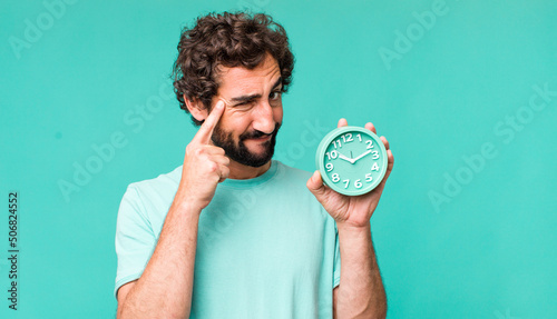 young adult hispanic crazy man with an alarm clock
