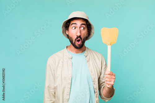 Leinwand Poster young adult hispanic crazy man with a fly swatter