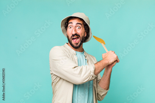 Foto young adult hispanic crazy man with a fly swatter