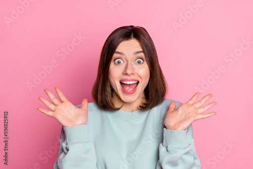Photo of impressed millennial lady arms up wear blue shirt isolated on pink color background © deagreez