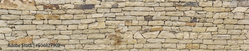 horizontal background  texture - wall of roughly hewn natural light stone