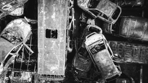 Obraz na płótnie Irpin, a lot of burnt shelled cars in the parking lot, the consequences of the invasion of the Russian army in Ukraine. War in Ukraine. Black and white drone photo w salonie