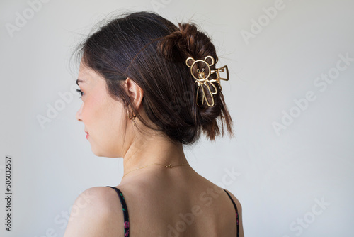Young woman with beautiful hair clips on grey background