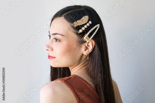 Young woman with beautiful hair clips on grey background